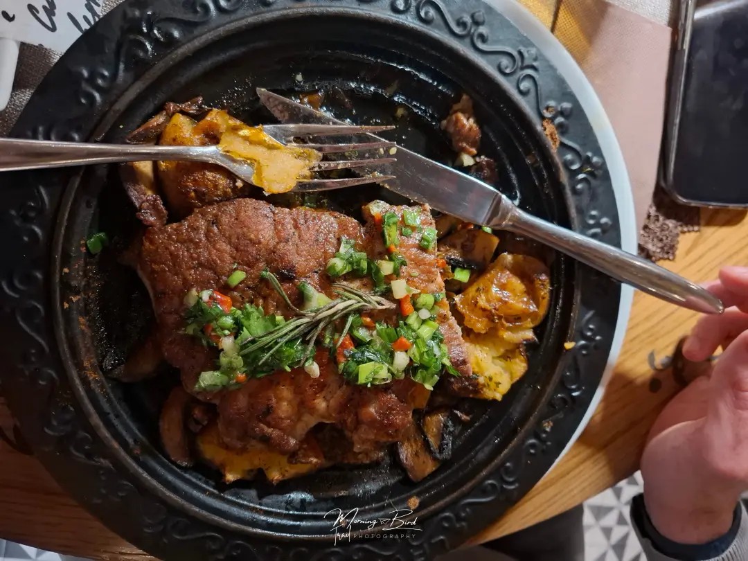 plate of traditional bulgarian food with meat and potato on a black plate