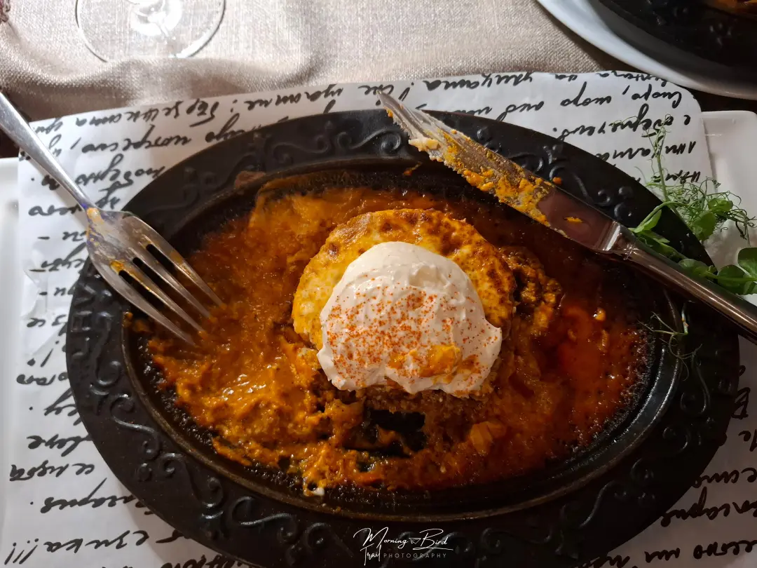 plate of traditional bulgarian food in a black plate with red and white sauces