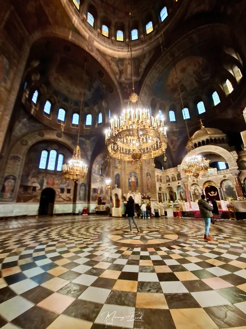 Inside paintings of Sofia Cathedral St. Alexander Nevsky walls and cupolas with brown yellow and white floor tiles, Bulgaria.