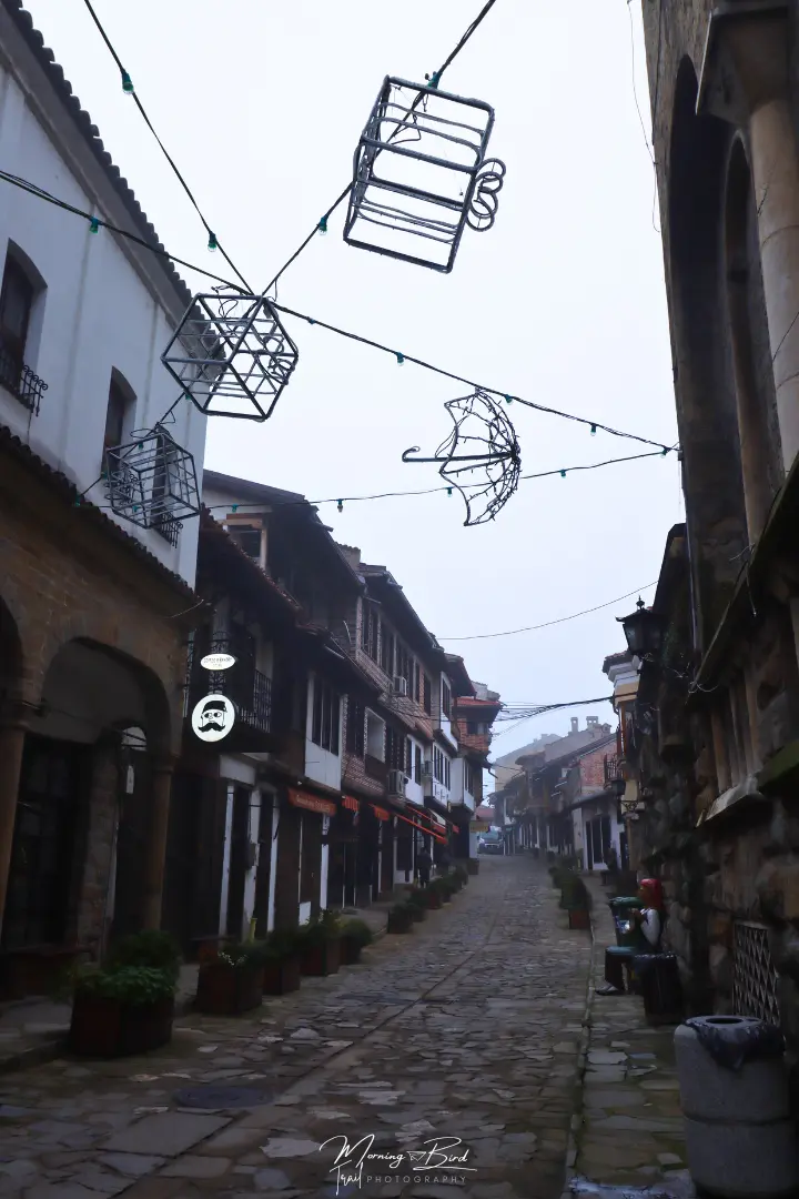 Cobblestone streets with traditional bulgarian houses in Veliko Tarnovo, Bulgaria, decorated with christmas lights 
