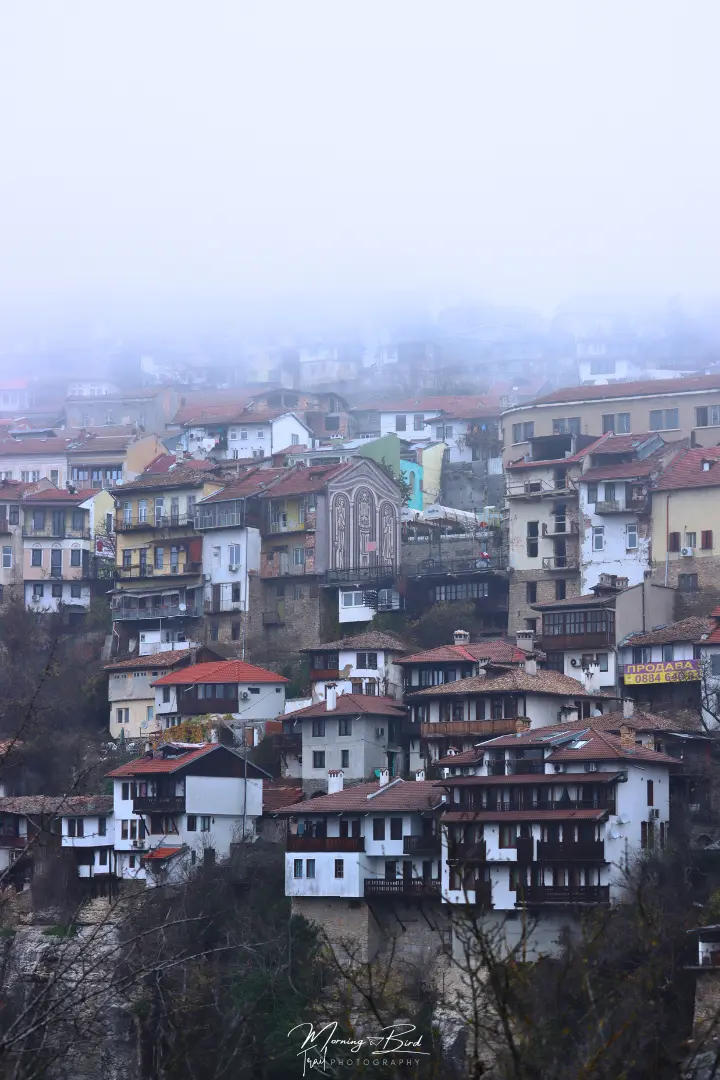view of Gurko Street from Asen's Monument. Houses of Veliko Tarnovo half hidden in the fog over the hill